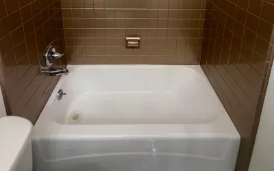 Refinished white bathtub with brown tile surround in a Kissimmee, FL bathroom