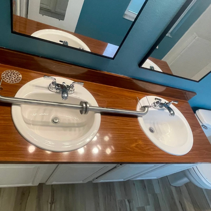 double-sink-vanity-countertop-resurfacing-before-kissimmee. Wood pattern laminate vanity countertop with double sinks before epoxy resurfacing in Kissimmee FL