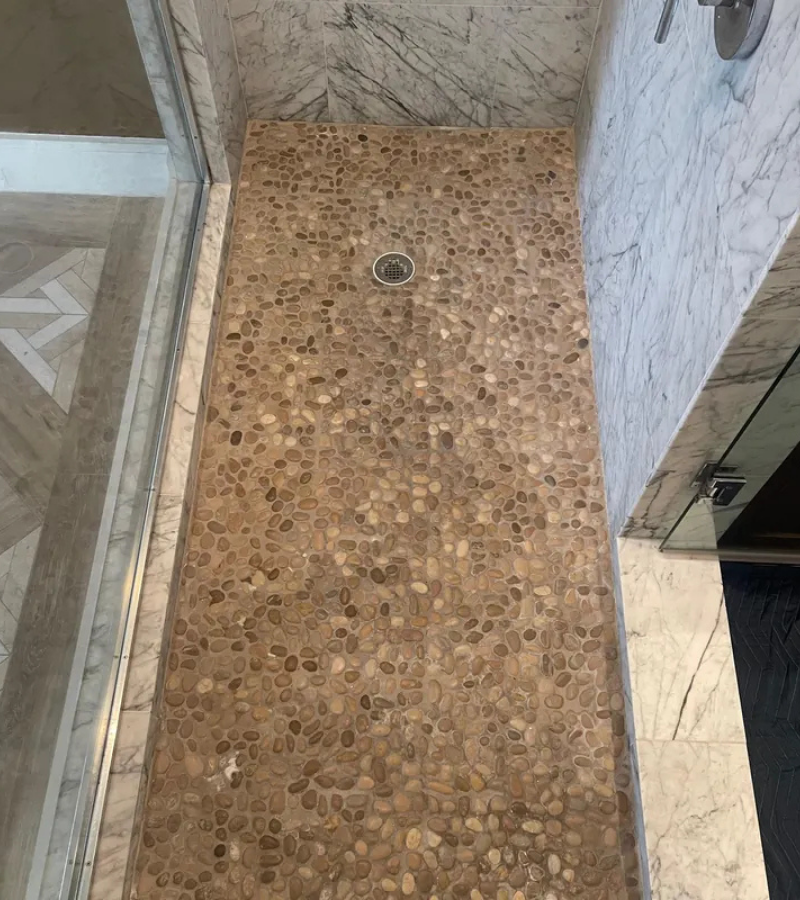 Worn pebble shower floor before refinishing in Kissimmee FL.