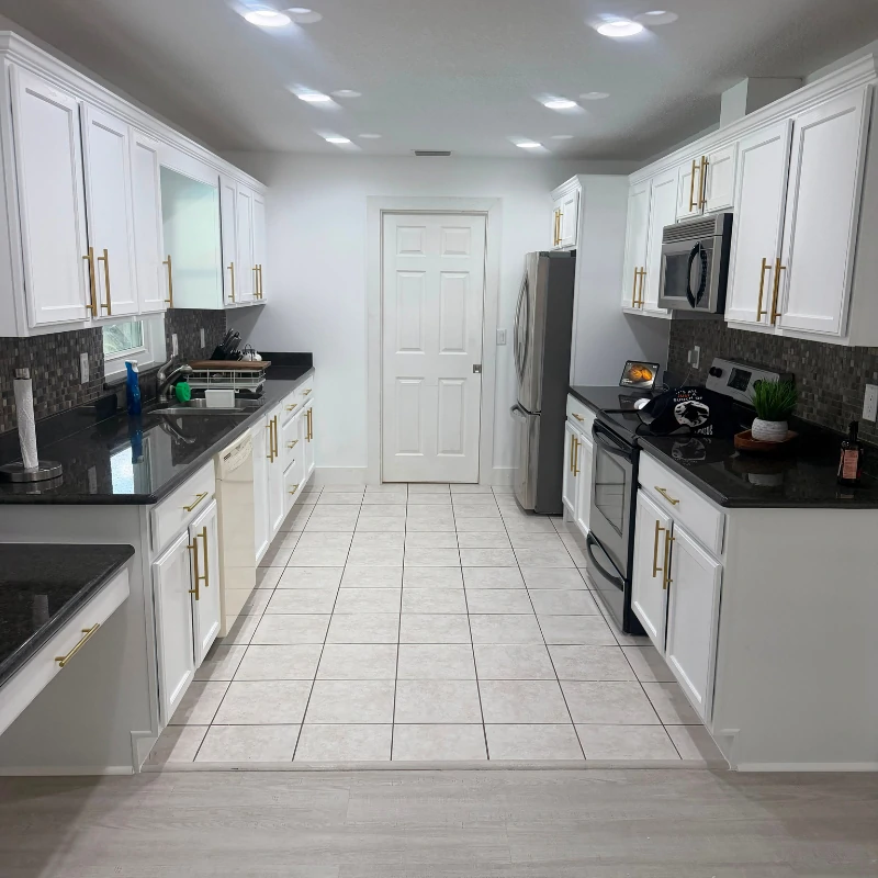 white-kitchen-cabinet-painting-after-kissimmee. Painted white kitchen cabinets with gold hardware after refinishing in Kissimmee FL
